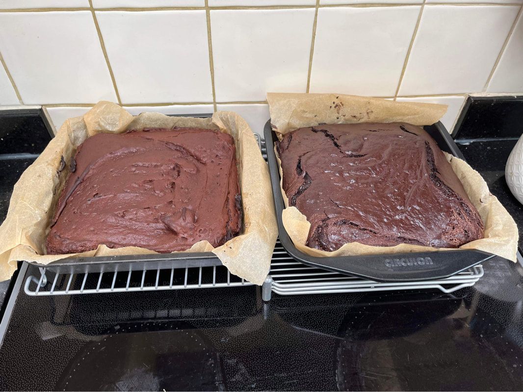 Two un-iced chocolate cakes in their tins